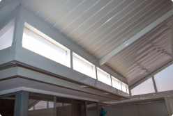 Modern Colorbond verandah with a sleek, open design, featuring a sturdy steel frame and a fibreglass roof. The verandah extends from the home's exterior, creating a functional outdoor space ideal for relaxation and entertainment.